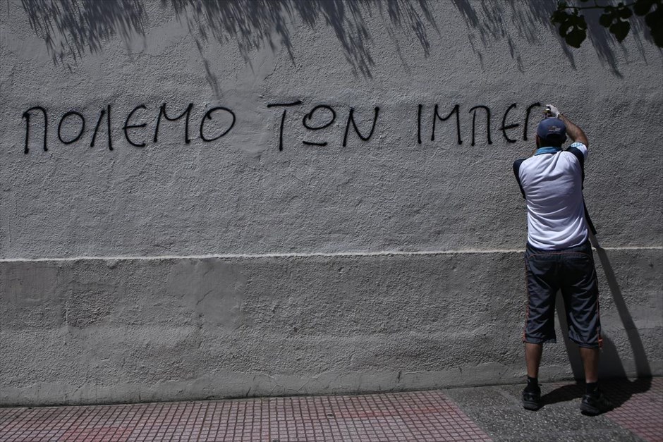 Πορεία αντιεξουσιαστών στην Αθήνα. Διαδηλωτής γράφει σύνθημα σε τοίχο, κατά τη διάρκεια πορείας διαμαρτυρίας που πραγματοποίησαν αντιεξουσιαστικές οργανώσεις στο κέντρο της Αθήνας.