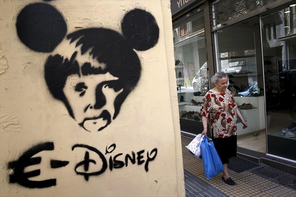 Στιγμιότυπο από το κέντρο της Αθήνας. Μια γυναίκα περπατά σε δρόμο της Αθήνας, ενώ δίπλα της διακρίνεται στένσιλ με τη φιγούρα της Γερμανίδας καγκελαρίου Άγκελα Μέρκελ. Σύμφωνα με την εφημερίδα Die Welt του Βερολίνου, η κ. Μέρκελ δεν βλέπει ως εναλλακτική λύση μία έξοδο της Ελλάδας από το ευρώ, θεωρεί τον πρωθυπουργό Αλέξη Τσίπρα «σοβαρό διαπραγματευτή», ενώ συνυπολογίζει την ιδιαίτερη στρατηγική σημασία της Ελλάδας στην ευρωπαϊκή περιφέρεια. Ο υπουργός Οικονομικών Βόλφγκανγκ Σόιμπλε, σύμφωνα με το ίδιο δημοσίευμα, φέρεται να έχει εντελώς διαφορετική άποψη, πιστεύοντας ότι η Ευρώπη θα εξασθενούσε σημαντικά τη διαπραγματευτική της θέση απέναντι στην Ελλάδα, εάν απέκλειε ένα Grexit.