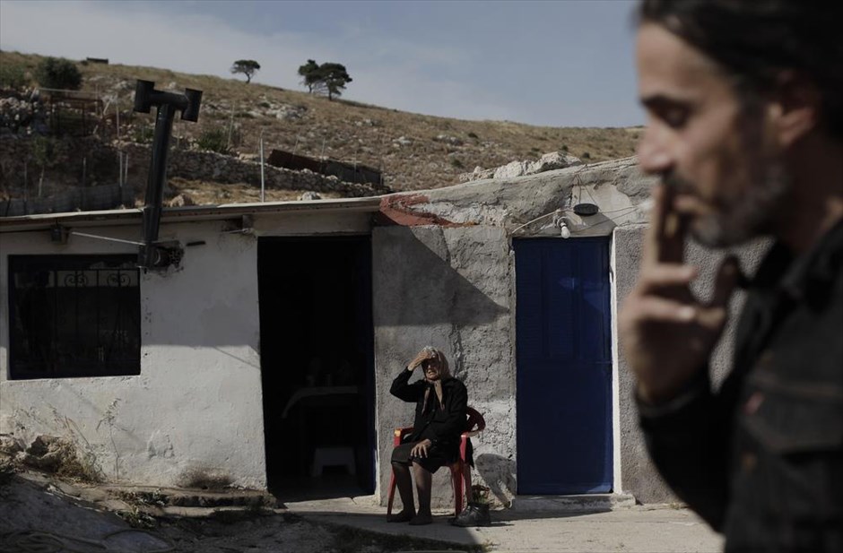 Η ζωή στο Πέραμα της κρίσης. Η συνταξιούχος Άννα Κούσουλα, 60 χρονών και ο 40χρονος γιος της, Στράτος, φωτογραφίζονται μπροστά από το σπίτι τους στο Πέραμα. Η κα. Άννα παίρνει 300 ευρώ σύνταξη χηρείας και συντηρεί τον γιο της, ο οποίος είναι άνεργος πάνω από τέσσερα χρόνια. Ο Στράτος δούλευε σαν οικοδόμος και ο κλάδος του είναι ένας από τους πρώτους που επλήγησαν από την οικονομική κρίση. Στο Πέραμα η ανεργία αγγίζει το 60%, ποσοστό τριπλάσιο του εθνικού μέσου όρου και πάρα πολλές οικογένειες είναι αναγκασμένες να ζουν με λιγότερο από 200 ευρώ το μήνα.