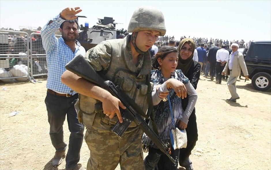 Πρόσφυγες από τη Συρία στην Τουρκία. Τούρκοι στρατιώτες βοηθούν Σύρους πρόσφυγες να διασχίσουν τα σύνορα Τουρκίας - Συρίας, κοντά στη νοτιοανατολική πόλη Ακτσάκαλε, στην επαρχία Σανλιούρφα.