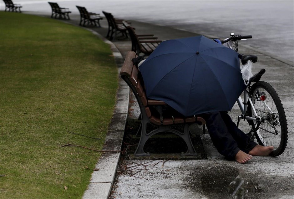Μια βροχερή μέρα στο Τόκιο. Ένας άνδρας ξεκουράζεται πάνω σε ένα παγκάκι, δίπλα σε πάρκο του Τόκιο.