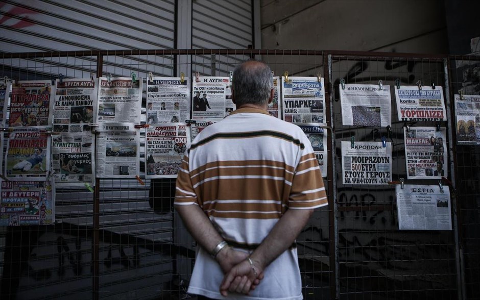 Στον ρυθμό του δημοψηφίσματος - Πρωτοσέλιδα. Ένας άντρας διαβάζει τα πρωτοσέλιδα των εφημερίδων.