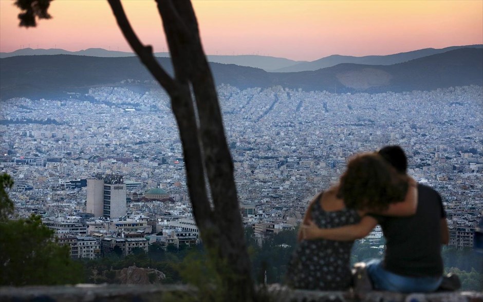 Ηλιοβασίλεμα από τον λόφο του Λυκαβηττού. Ζευγάρι παρακολουθεί τον ήλιο να βασιλεύει από τον λόφο του Λυκαβηττού.