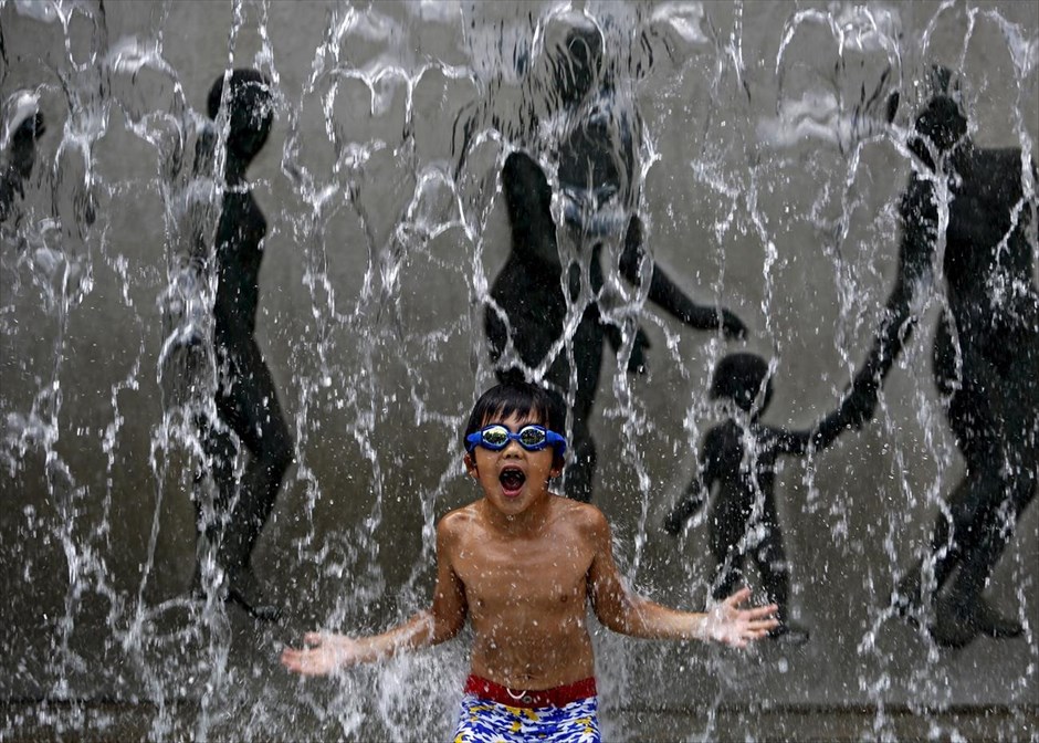 Παιχνίδια με το νερό στο Τόκιο. Ένα αγόρι παίζει με τα νερά σιντριβανιού στο Τόκιο. 