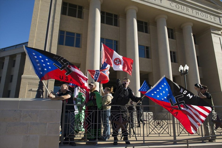 Κου Κλουξ Κλαν. Μέλη του Εθνικοσοσιαλιστικού Κινήματος και της οργάνωσης «Λευκοί ιππότες της αδελφότητας Αντιροντάκ» κυματίζουν σημαίες, καθώς διαδηλώνουν έξω από δικαστήριο στην πόλη Ρόκγουολ του Τέξας.