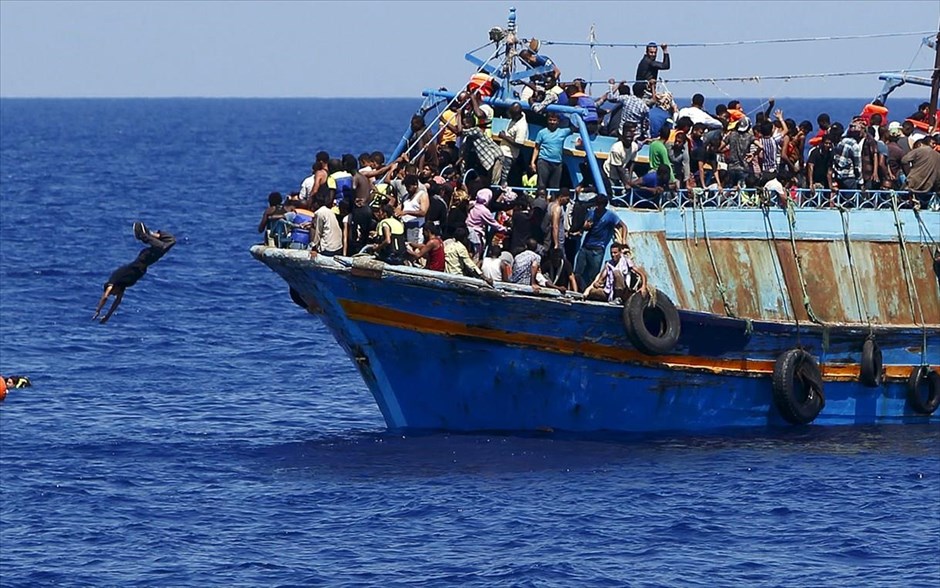 Προσφυγικό - μετανάστες - πρόσφυγες - Λιβύη. Ένας άνδρας βουτά από το υπερφορτωμένο πλοίο στο οποίο επιβαίνει μαζί με 600 ακόμη άτομα, κατά τη διάρκεια επιχείρησης διάσωσης.