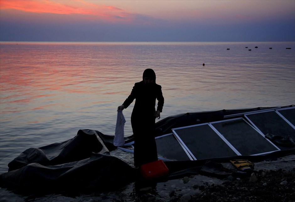 Προσφυγικό - Μετανάστες - Πρόσφυγες - Κως. Μια γυναίκα ψάχνει για τα υπάρχοντά της στο σκάφος με το οποίο έφτασε σε ακτή της Κω.