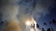 Ελικόπτερο κάνει ρίψη νερού πάνω από πυρκαγιά κοντά στην πόλη Ούρεμ, στην ...