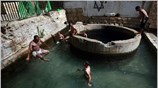 Παλαιστίνιοι δροσίζονται σε φυσική πηγή κοντά στην Ιεριχώ.  ...
