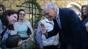 Ο πρόεδρος του ΠΑΣΟΚ Γιώργος Παπανδρέου χαιρετά ένα παιδάκι, στο εκλογικό κέντρο ...