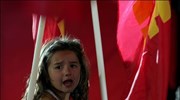 Ένα κοριτσάκι ανάμεσα σε σημαίες του ΚΚΕ στην κεντρική προεκλογική συγκέντρωση του ...