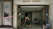 Υπάλληλοι της Εθνικής Τράπεζας στην οδό Σόλωνος 75 καθαρίζουν τα σπασμένα τζάμια ...